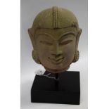 A museum-type cast model, of the head of an Indian deity, rectangular display plinth,