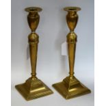 A pair of George III brass candlesticks, urnular sconces, stepped square bases,