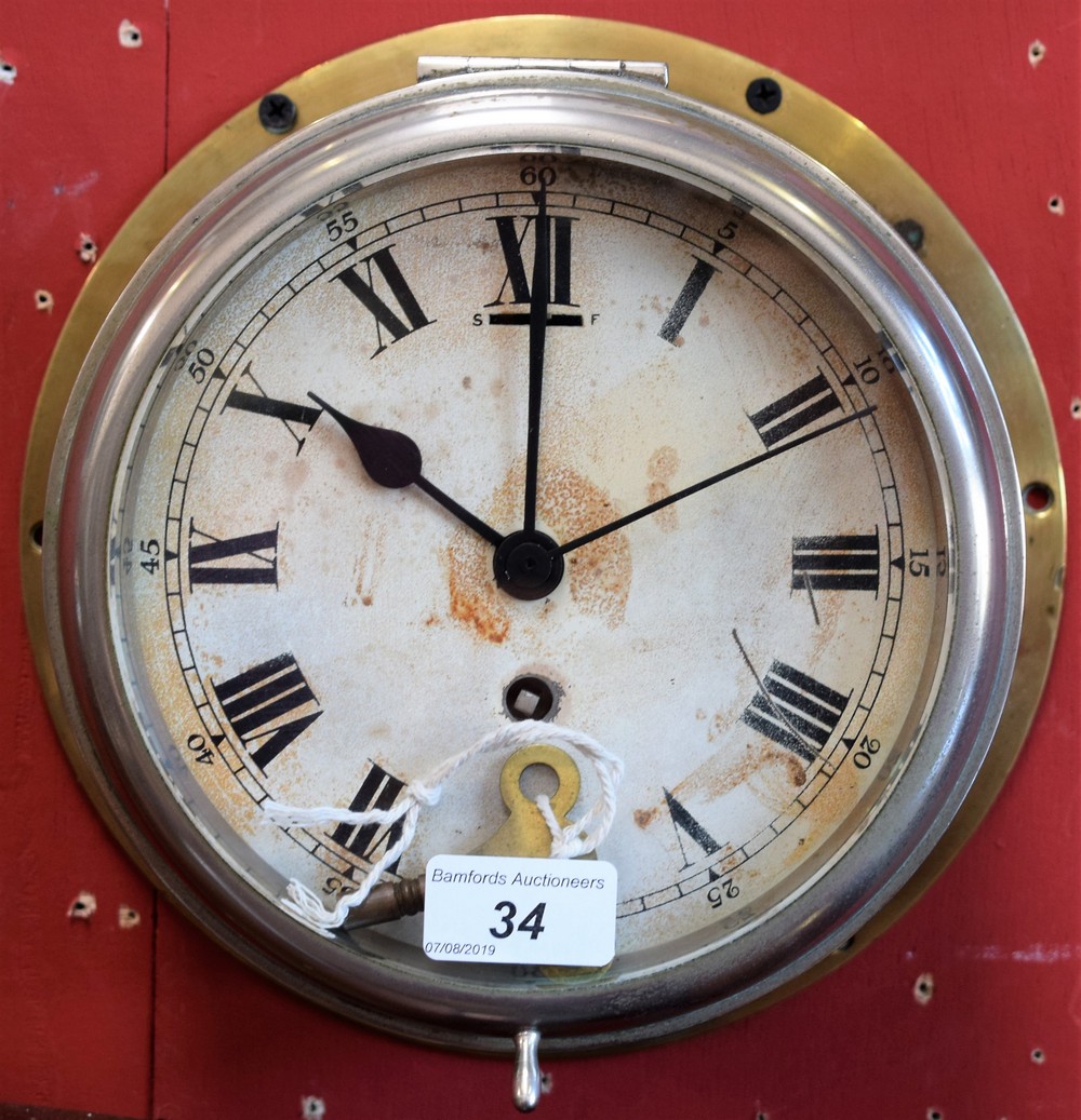 An early 20th century brass ship's clock, Roman numerals, minute track, single winding hole,