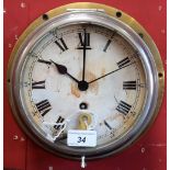 An early 20th century brass ship's clock, Roman numerals, minute track, single winding hole,
