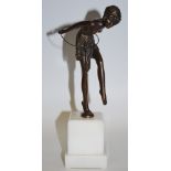 A bronzed figure of a dancing girl with hula hoop, white plinth base.