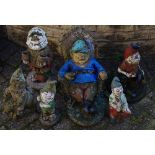 Garden statuary - reconstituted stone gnomes including relaxing in the armchair after work;