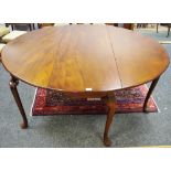 A George III mahogany dropleaf dining table, oval top, cabriole legs, club feet.