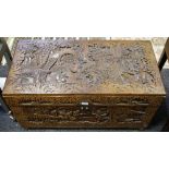 An oriental camphor wood chest profusely carved with oriental scenes throughout.