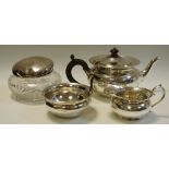 A silver tea service comprising teapot, milk and sugar; a white metal topped glass jar.