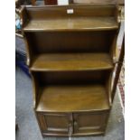 An oak floor standing waterfall bookcase, shaped uprights,