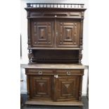 A Flemish oak cupboard, spindled gallery, block fronted cupboard doors over recess,