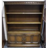 An oak floor standing bookcase, adjustable shelves over two panel door cupboard, plinth base. 137.