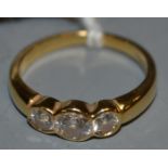 An 18ct gold three stone diamond ring, three linear round brilliant cut diamonds,