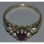 A garnet and diamond accented cluster ring, white metal shank, stamped 1696. 1.