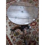 A George III oak occasional table, circular tilting top above a birdcage undertier, turned column,