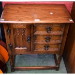 An oak hall cupboard, rectangular top above three short drawers neighbored by a Gothic moulded door,
