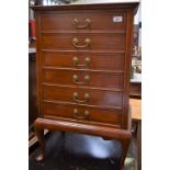 A 20th century mahogany music cabinet, oversailing rectangular top above six crossbanded drawers,