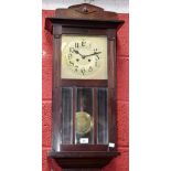 An early 20th century mahogany cased wall clock, brass dial, bold Arabic numerals,