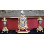 An ornate clock garniture, in the French style, gilt metal, emerald green ceramic urns and columns,