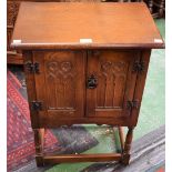 An oak hall cupboard, oversailing rectangular top above a pair of Gothic moulded panel doors,