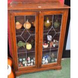 An oak bookcase, half gallery top above a pair of glazed doors enclosing two shelves, 123.