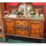 A Jacobean Revival oak sideboard, tall arched gallery centred by a mirror,