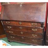 A George III oak bureau, fall front enclosing an arrangement of small drawers,