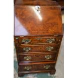 A George III style walnut bureau, of narrow proportions, fall front enclosing a writing surface,