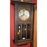 An early 20th century oak rectangular wall clock,