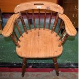 A pine smoker's bow elbow chair, curved cresting rail, spindle back, turned arm posts, H-stretcher,
