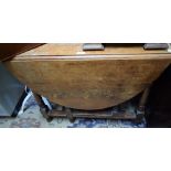 A 20th century oak gateleg dining table, moulded top with fall leaves, turned supports,