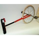 A unicycle, painted red ***PLEASE NOTE THERE IS NO BUYER'S PREMIUM ON THIS LOT,