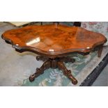 A reproduction Victorian style coffee table, serpentine top, acanthus grasped column, quadform base,