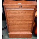 An oak tambour front stationery cabinet