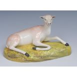 A Brameld model, of a deer, reclining, tan markings, shaped green oval base, 19cm wide, c.