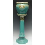 A Wardle Majolica jardinière and stand, in relief with fronds, in olive green on a turquoise ground,