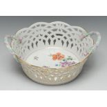 A Berlin two handled basket, painted with flowers, pierced sides, rustic handles, 23cm diam,