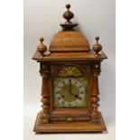 An oak Junghans bracket clock, brass dial with silvered chapter ring, Roman numerals, minute track,