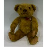 A teddy bear, mid 20th century, straw filled body,