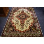 A woollen rug with floral cartouche and motifs in a burgundy,