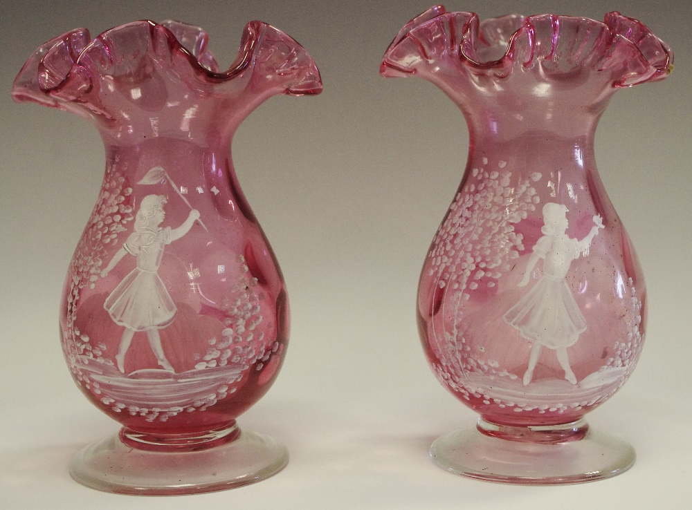 A near pair of Mary Gregory flared cylindrical cranberry glass vases decorated with young girl in