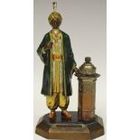 An early 20th century painted spelter taper stand cast as a Moorish gentleman in the manner of