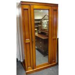 An Edwardian mahogany wardrobe central mirrored door, flanked B7 panels,