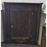 A George III oak corner cupboard, inlaid ebony shield shaped border,