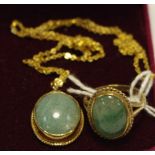 A 9ct gold pendant and ring suite, each set with a green stone oval cabochon, possibly jade,