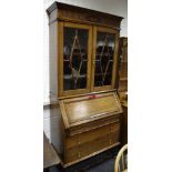 An oak bureau bookcase, ogee cornice, nulled frieze, astragal glazed doors enclosing shelving to to,