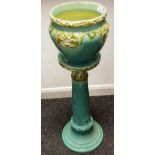 A Wardle Majolica jardinière and stand, in relief with fronds, in olive green on a turquoise ground,