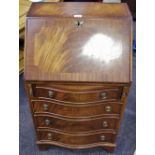 A reproduction mahogany bureau of small proportions, fall front enclosing pigeon holes,