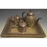 An Indian silver coloured metal three piece tea service on tray, comprising teapot,