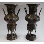 A pair of Japanese patinated bronze vasular tripod censers,