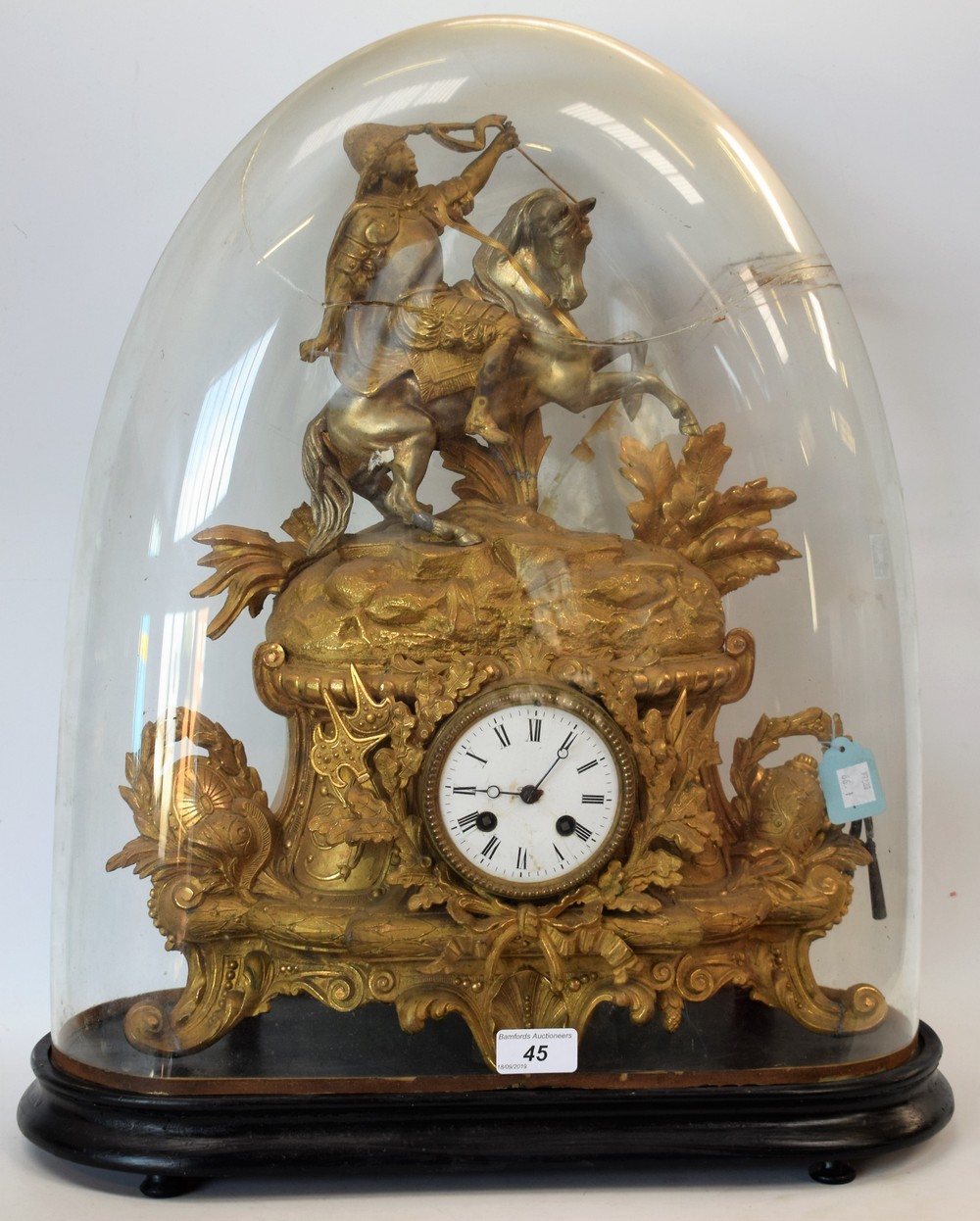 A gilt brass figural mantel clock, glass dome (faults),