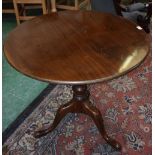 A George III style mahogany tripod occasional table, circular tilting top on birdcage support,