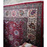 A Middle Eastern woollen carpet, the field colourfully worked with stylised flowers and motifs,