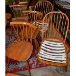 A set of four Ercol elm seated dining/side chairs, each with a curved cresting rail,